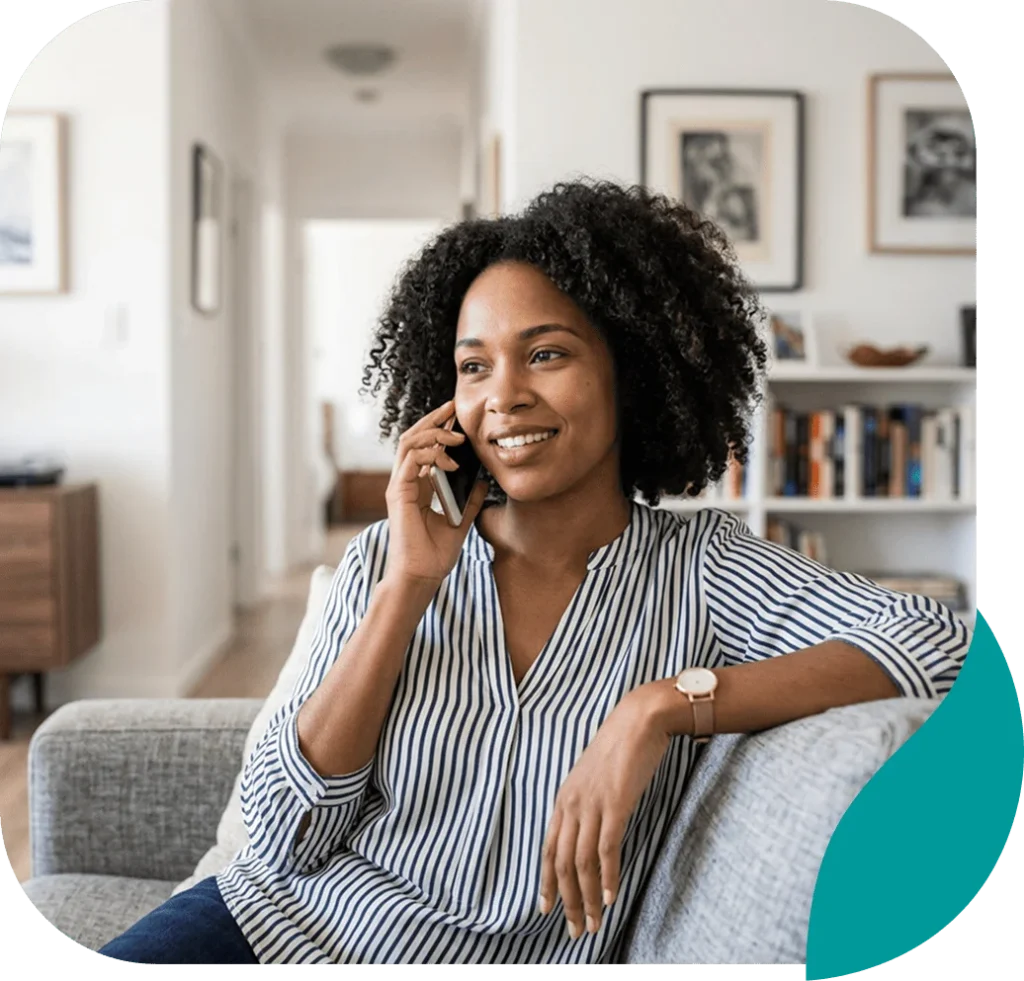 Smiling woman talking on her phone while relaxing on a sofa at home